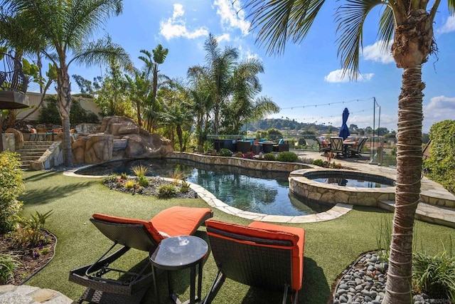 view of pool with a lawn and an in ground hot tub