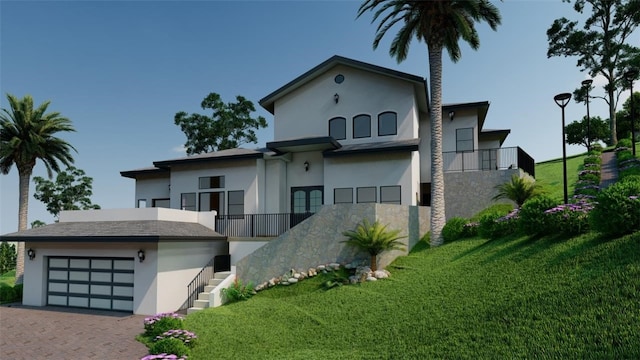 view of front of home featuring a garage, a front yard, and a balcony