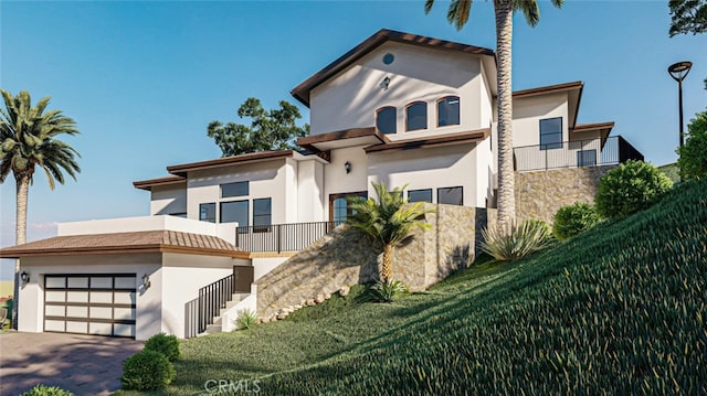 mediterranean / spanish-style house featuring a garage and a balcony