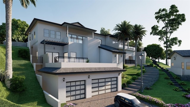 rear view of house with a garage, a balcony, and a lawn