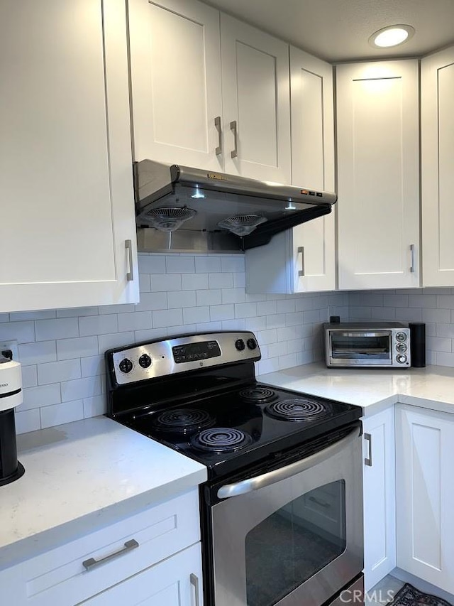 kitchen with stainless steel range with electric stovetop, tasteful backsplash, exhaust hood, and white cabinets