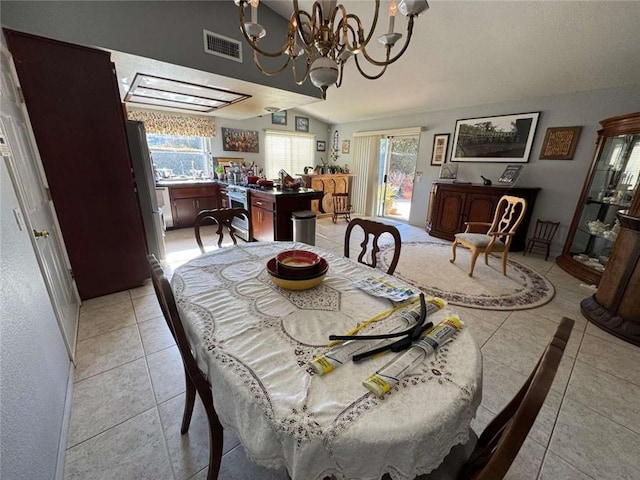 tiled dining room featuring lofted ceiling and an inviting chandelier