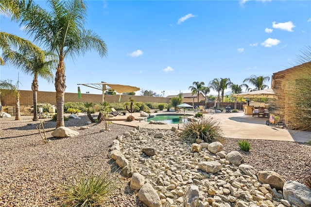 exterior space with a fenced in pool and a patio