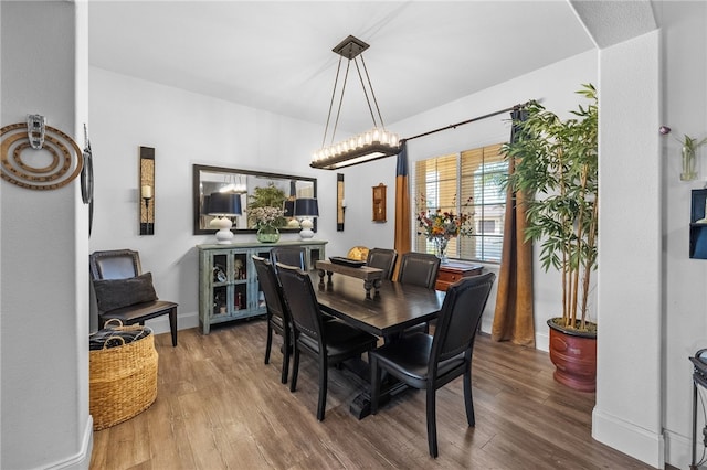 dining room featuring wood-type flooring and an inviting chandelier