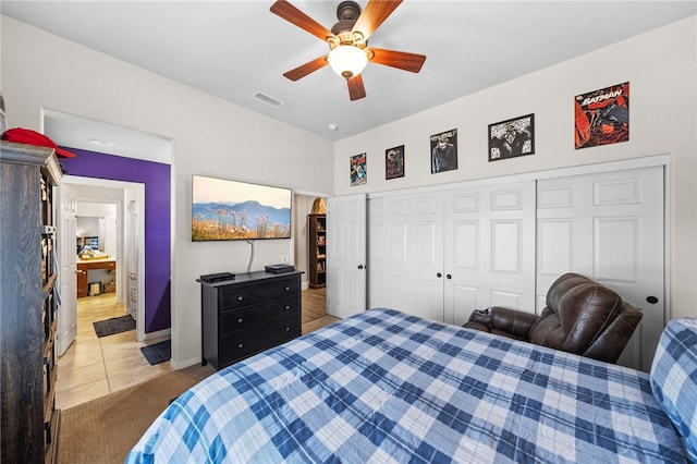 bedroom featuring light tile patterned floors, ceiling fan, and a closet