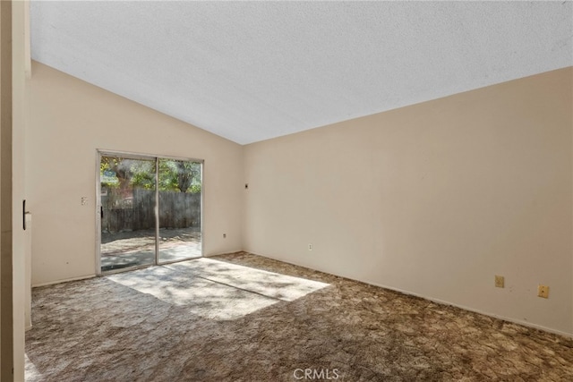 unfurnished room featuring vaulted ceiling, carpet floors, and a textured ceiling