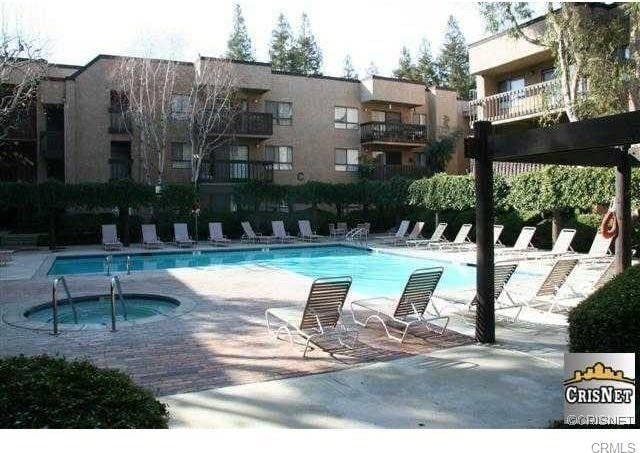 view of swimming pool featuring a hot tub and a patio