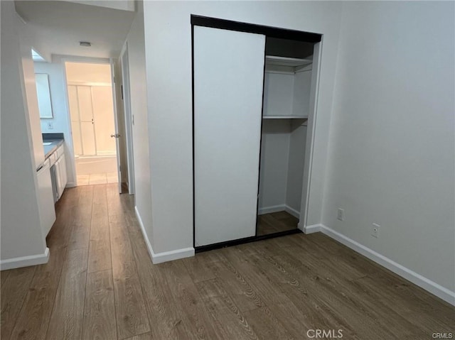 unfurnished bedroom featuring hardwood / wood-style floors and a closet