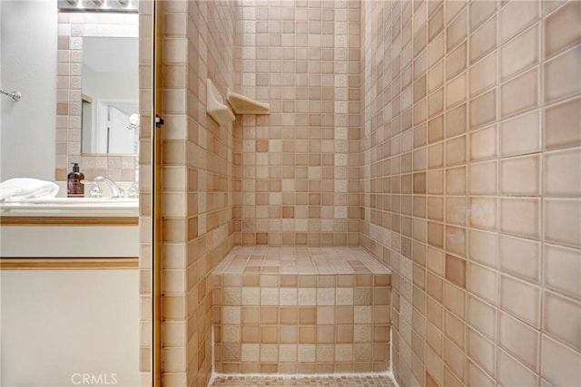 bathroom featuring a tile shower and vanity