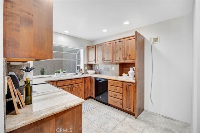 kitchen with black dishwasher, brown cabinets, tasteful backsplash, light tile patterned flooring, and a sink