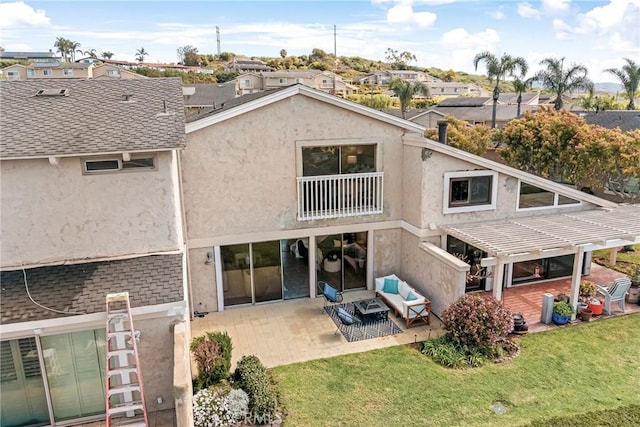 back of property featuring a lawn, a patio area, a residential view, and stucco siding