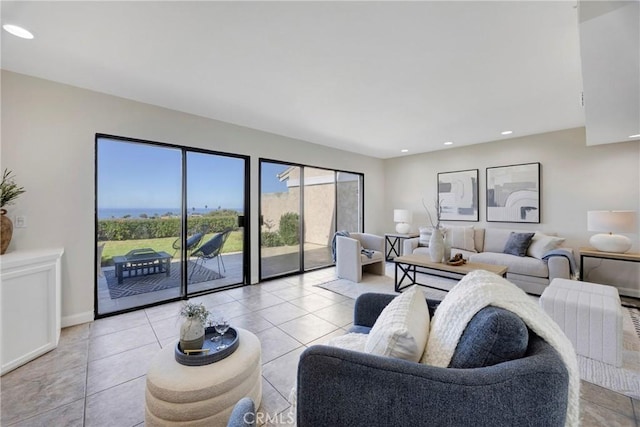 living room featuring baseboards, light tile patterned flooring, and recessed lighting