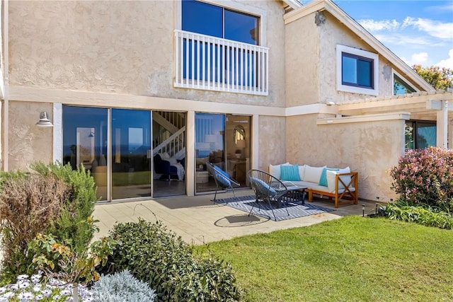 back of house with a patio area, a yard, an outdoor hangout area, and stucco siding