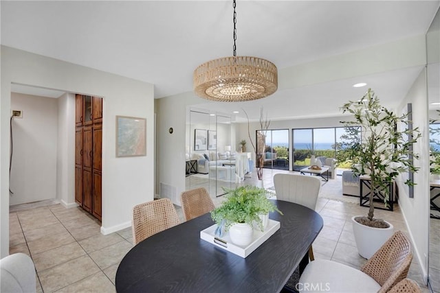 dining area featuring light tile patterned floors, baseboards, and a notable chandelier