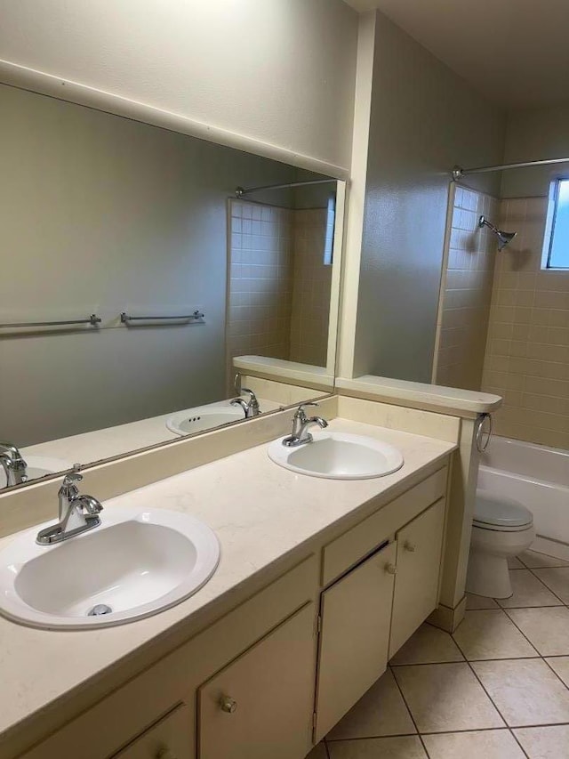 full bathroom featuring tile patterned flooring, vanity, tiled shower / bath, and toilet