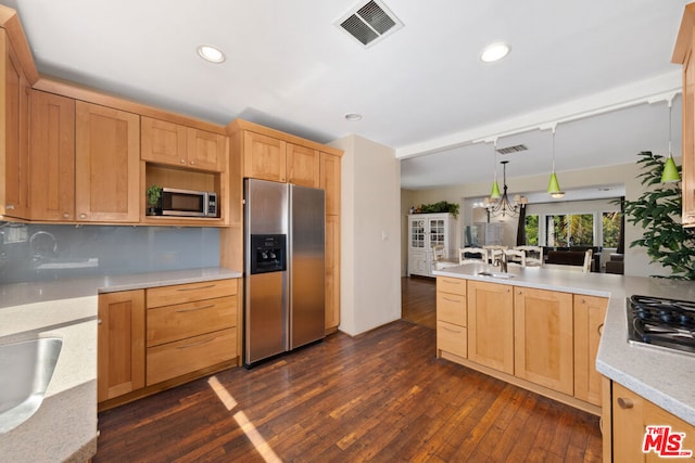 kitchen with backsplash, hanging light fixtures, stainless steel appliances, dark wood-type flooring, and light brown cabinets