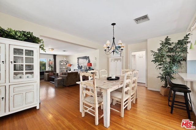 dining area featuring a chandelier and light hardwood / wood-style flooring