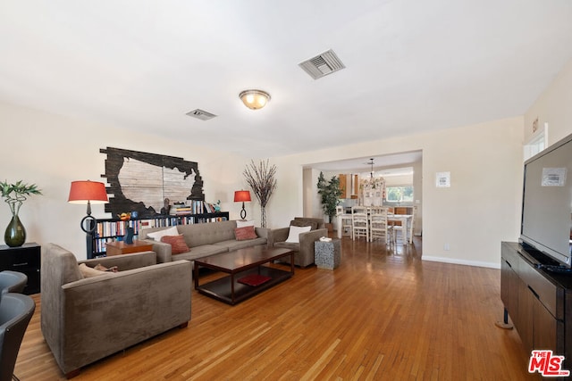 living room with an inviting chandelier and light hardwood / wood-style floors