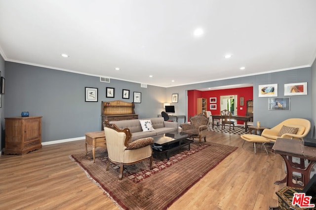 living room featuring ornamental molding and light hardwood / wood-style flooring