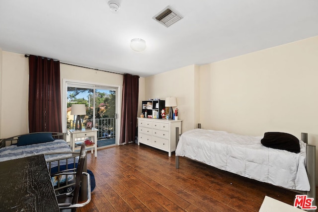 bedroom with access to exterior and dark hardwood / wood-style floors