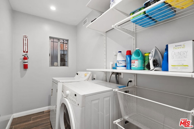 laundry area with washing machine and clothes dryer and dark hardwood / wood-style flooring