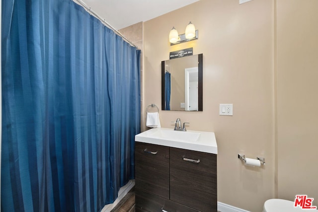 bathroom featuring a shower with curtain, vanity, and toilet