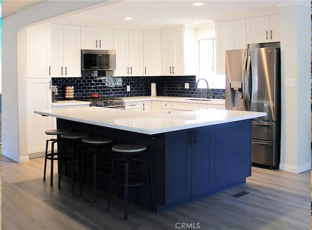 kitchen with white cabinetry, a spacious island, and appliances with stainless steel finishes