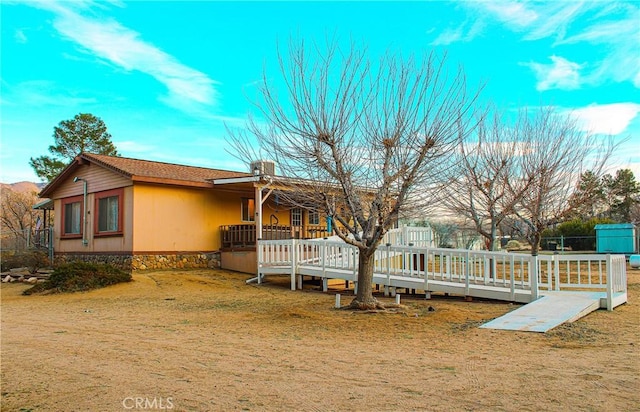 view of side of property featuring a wooden deck and a lawn