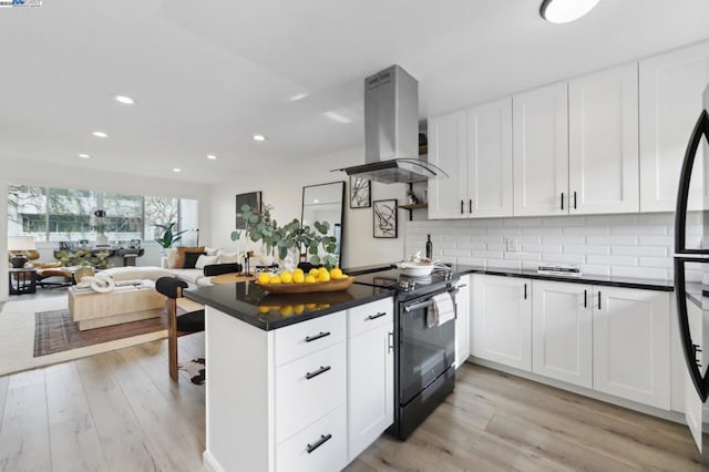 kitchen with white cabinetry, island range hood, black appliances, and decorative backsplash