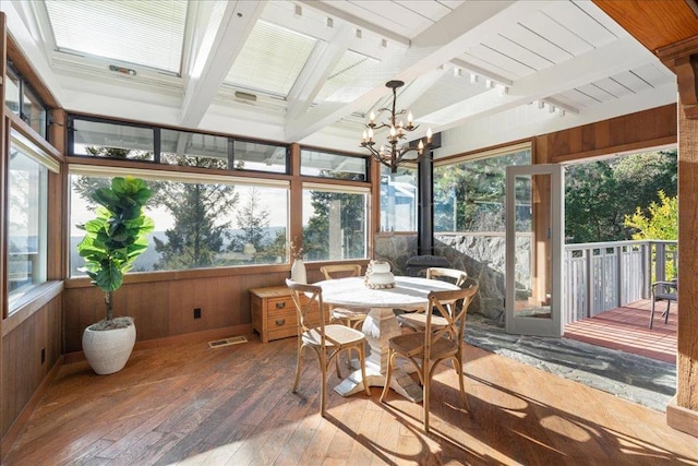 sunroom / solarium featuring lofted ceiling with beams and a chandelier