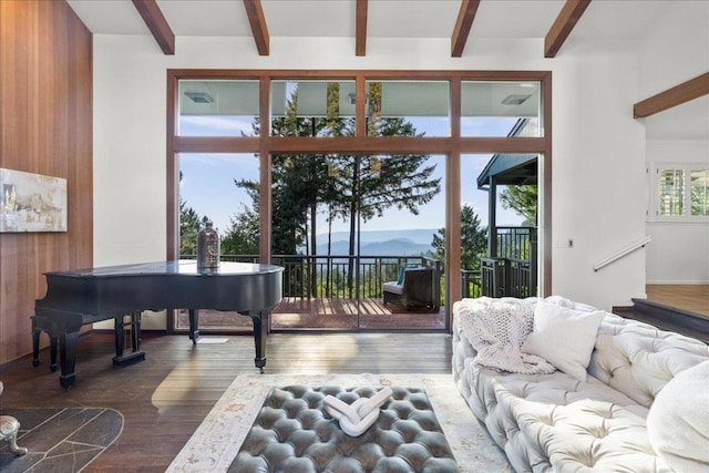 living room with a mountain view, beam ceiling, and wood walls