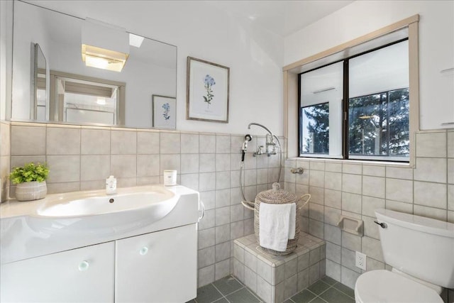 bathroom with tile patterned flooring, vanity, tile walls, and toilet