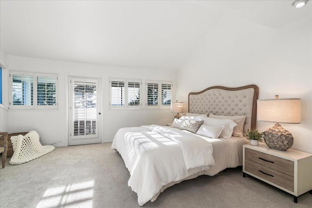 bedroom featuring vaulted ceiling, light carpet, and access to exterior