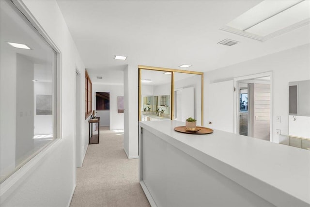 hallway featuring light colored carpet