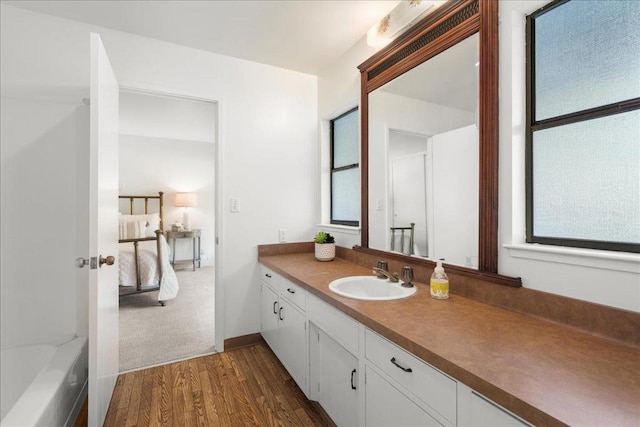 bathroom featuring vanity, hardwood / wood-style floors, and a bathing tub