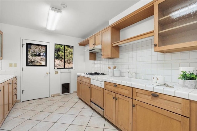 kitchen featuring light tile patterned flooring, gas cooktop, tile counters, and decorative backsplash