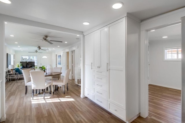 dining space with ceiling fan and light wood-type flooring