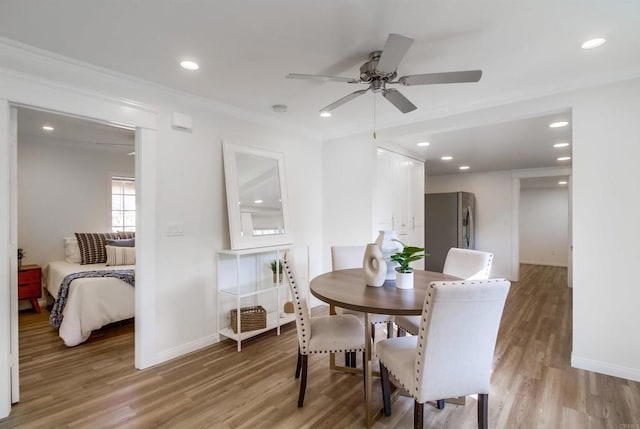 dining space with hardwood / wood-style flooring, crown molding, and ceiling fan