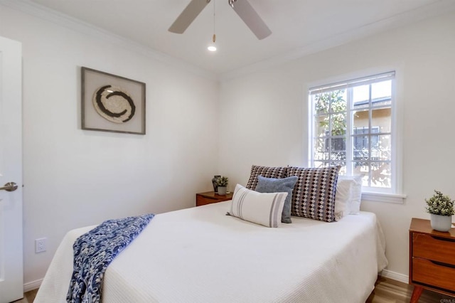 bedroom with crown molding, hardwood / wood-style flooring, and ceiling fan