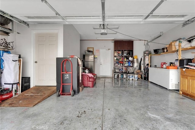 garage with water heater, a garage door opener, and stainless steel refrigerator