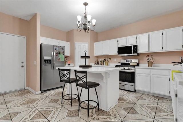 kitchen featuring a kitchen bar, white cabinetry, decorative light fixtures, a center island, and appliances with stainless steel finishes