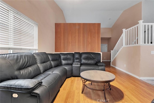 living room featuring lofted ceiling and light hardwood / wood-style flooring