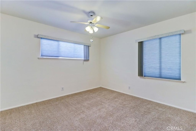 spare room with ceiling fan and carpet