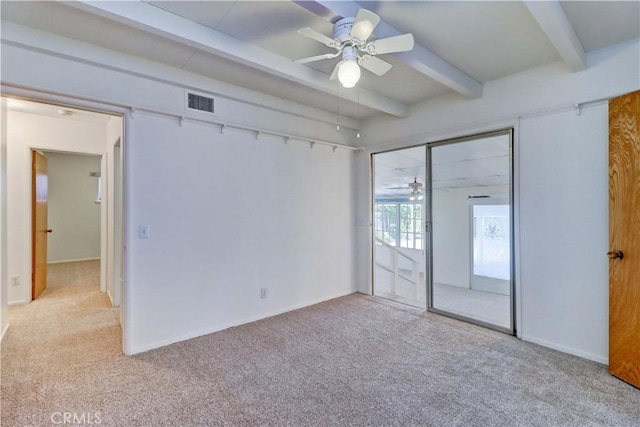 carpeted spare room with beamed ceiling and ceiling fan