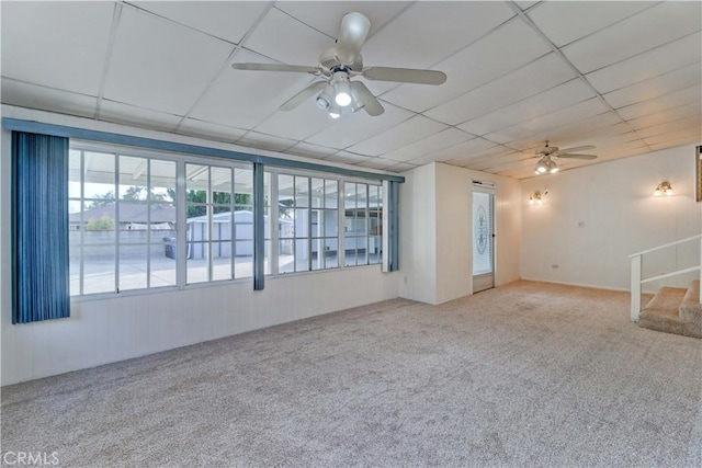 carpeted spare room with a paneled ceiling and ceiling fan