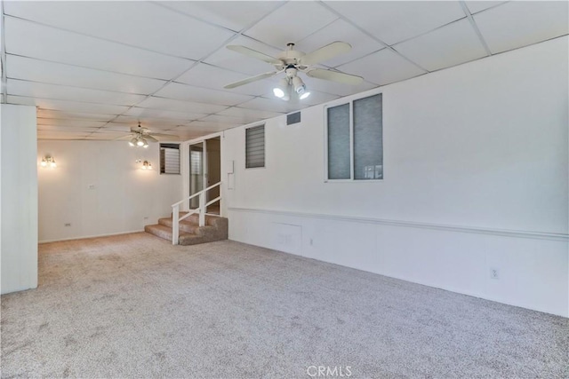 carpeted empty room with a paneled ceiling and ceiling fan