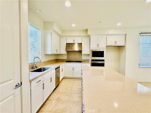 148 Stage, Irvine, CA 92618 - kitchen with sink, white cabinetry, light tile patterned floors, stainless steel appliances, and light stone countertops