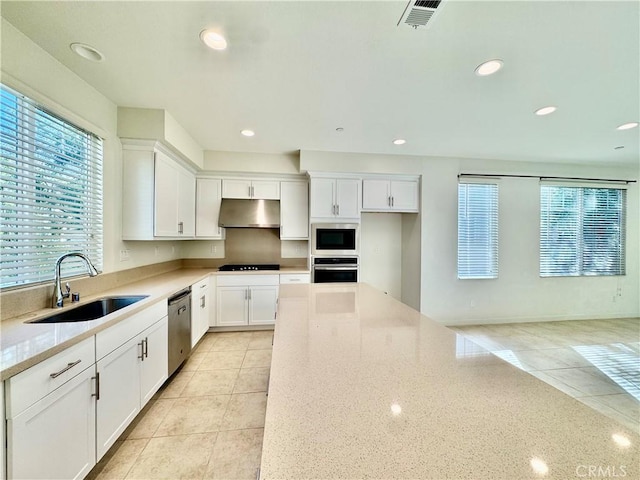 kitchen with white cabinetry, sink, light tile patterned floors, light stone counters, and stainless steel appliances