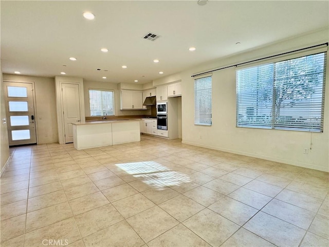 148 Stage, Irvine, CA 92618 - kitchen with white cabinetry, plenty of natural light, a center island, and light tile patterned floors