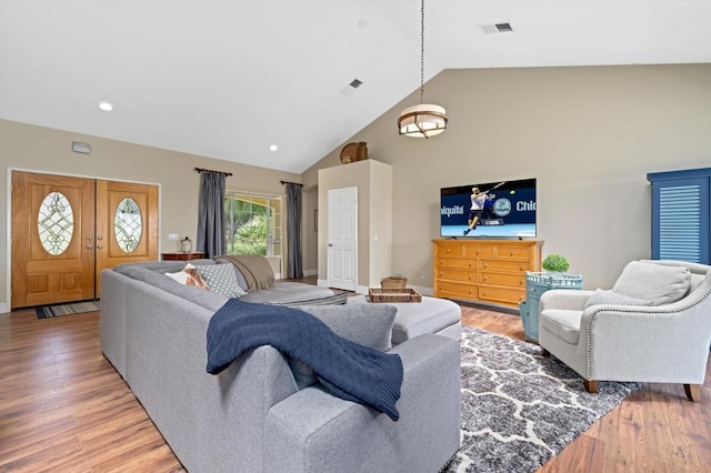 living room featuring hardwood / wood-style flooring and high vaulted ceiling